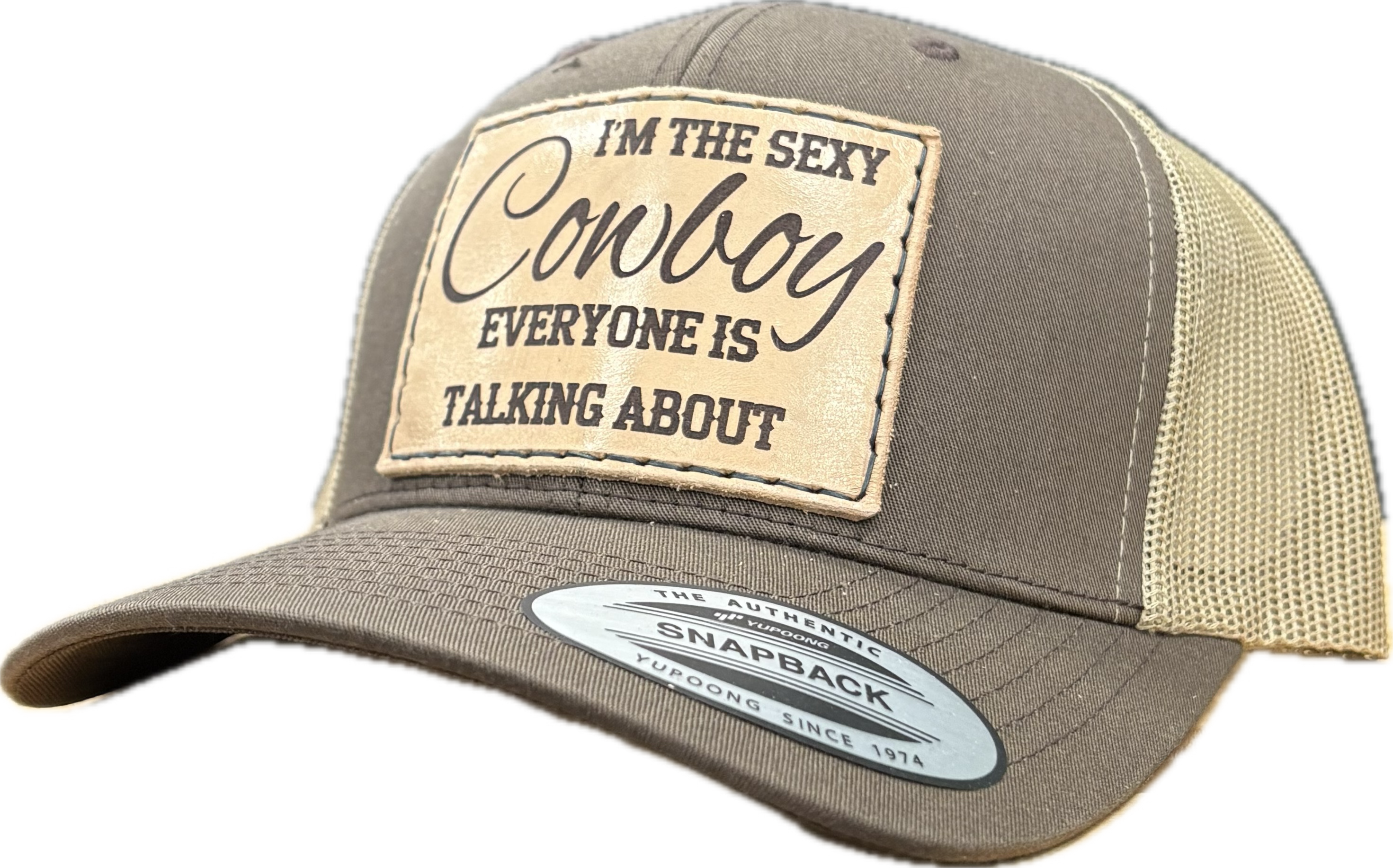 Brown and beige cap with a patch reading 'I'm the sexy cowboy everyone is talking about' on a white background.