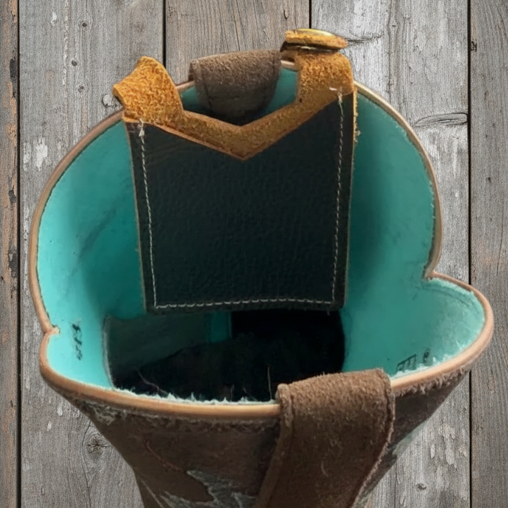 Hand holding a small leather pouch with teal interior against a gray background