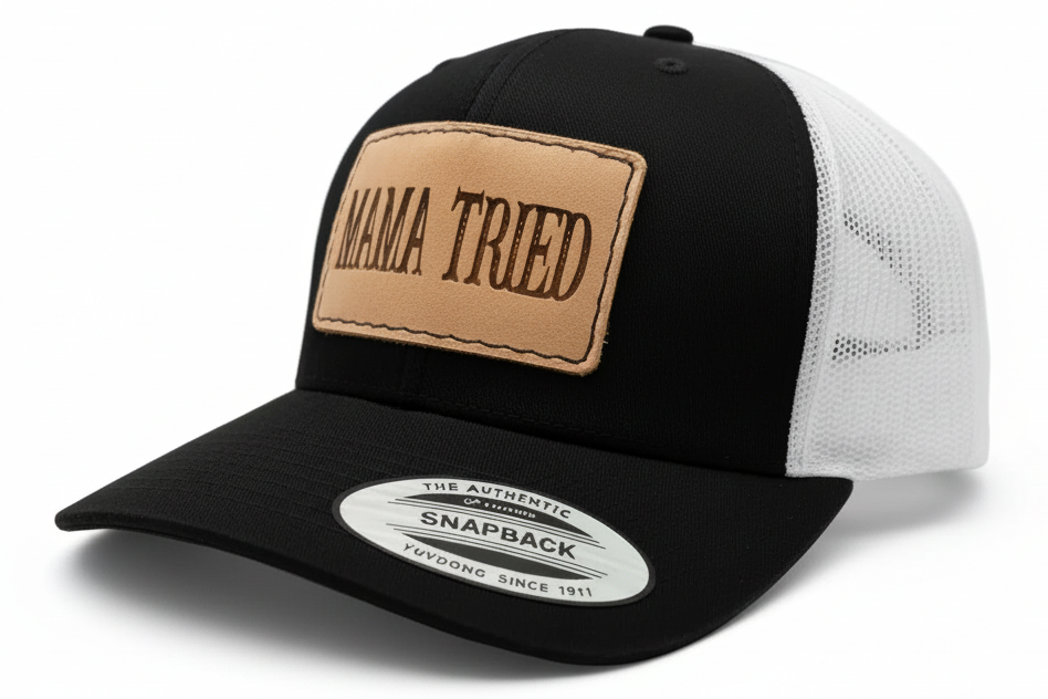 Black trucker cap with a brown leather patch and 'MAMA TRIED' text on a light gray background.