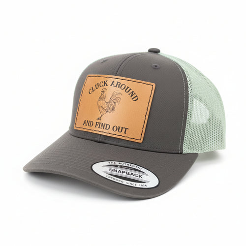 Gray cap with a leather patch featuring a rooster and text on a brown fur background