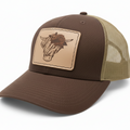 Brown and beige trucker cap with a leather patch featuring a bull's head on a white background
