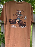 Brown t-shirt with a graphic design of a woman holding a lasso on a wooden fence with greenery in the background.