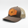 Brown and beige cap with a sunflower patch on a white background