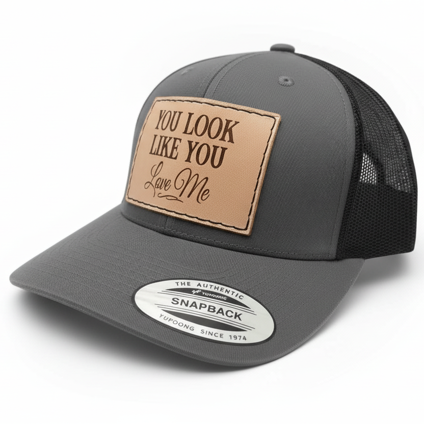 Gray trucker cap with a brown leather patch and  label on a white background
